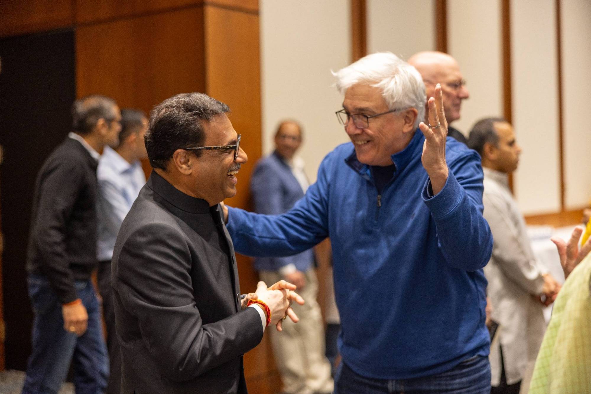 J. R. Sandadi and Rev. Jerry Zehr greeting each other warmly at a community gathering